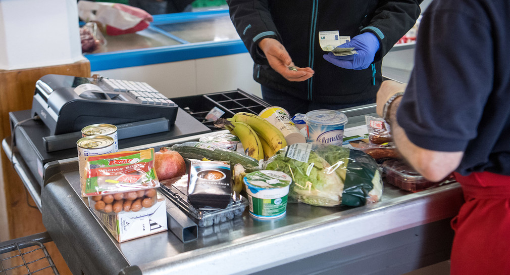 Eine Verkäuferin kassiert im Ulmer Tafelladen die Lebensmittel eines Kunden ab. (Bild: dpa)