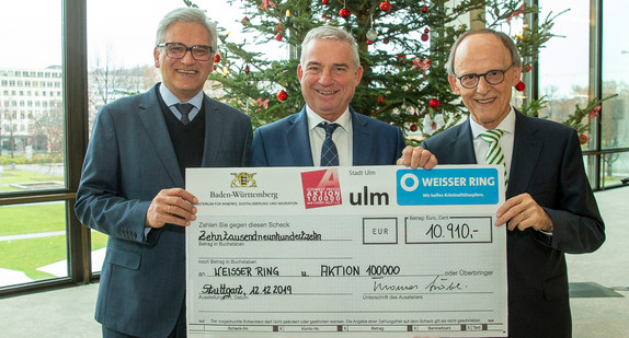Innenminister Thomas Strobl (Mitte) übergibt den Spendenscheck an Oberbürgermeister und Schirmherr der Aktion 100 000 Gunter Czisch (links) und den Landesvorsitzenden des WEISSEN RINGS Erwin Hetger (rechts).