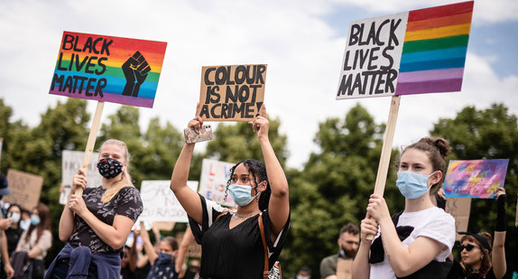 „Black Lives Matter“ und „Color Is Not A Crime“ steht auf Schildern von jungen Frauen, die unter dem Motto „Solidarität mit George Floyd“ an einer Demonstration gegen Rassismus teilnehmen.