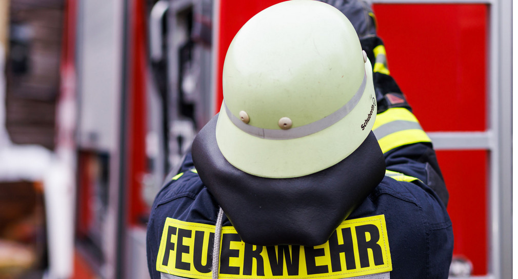 Ein Feuerwehrmann holt während einer Einsatzübung einer Freiwilligen Feuerwehr eine Leiter vom Dach eines Einsatzfahrzeugs.