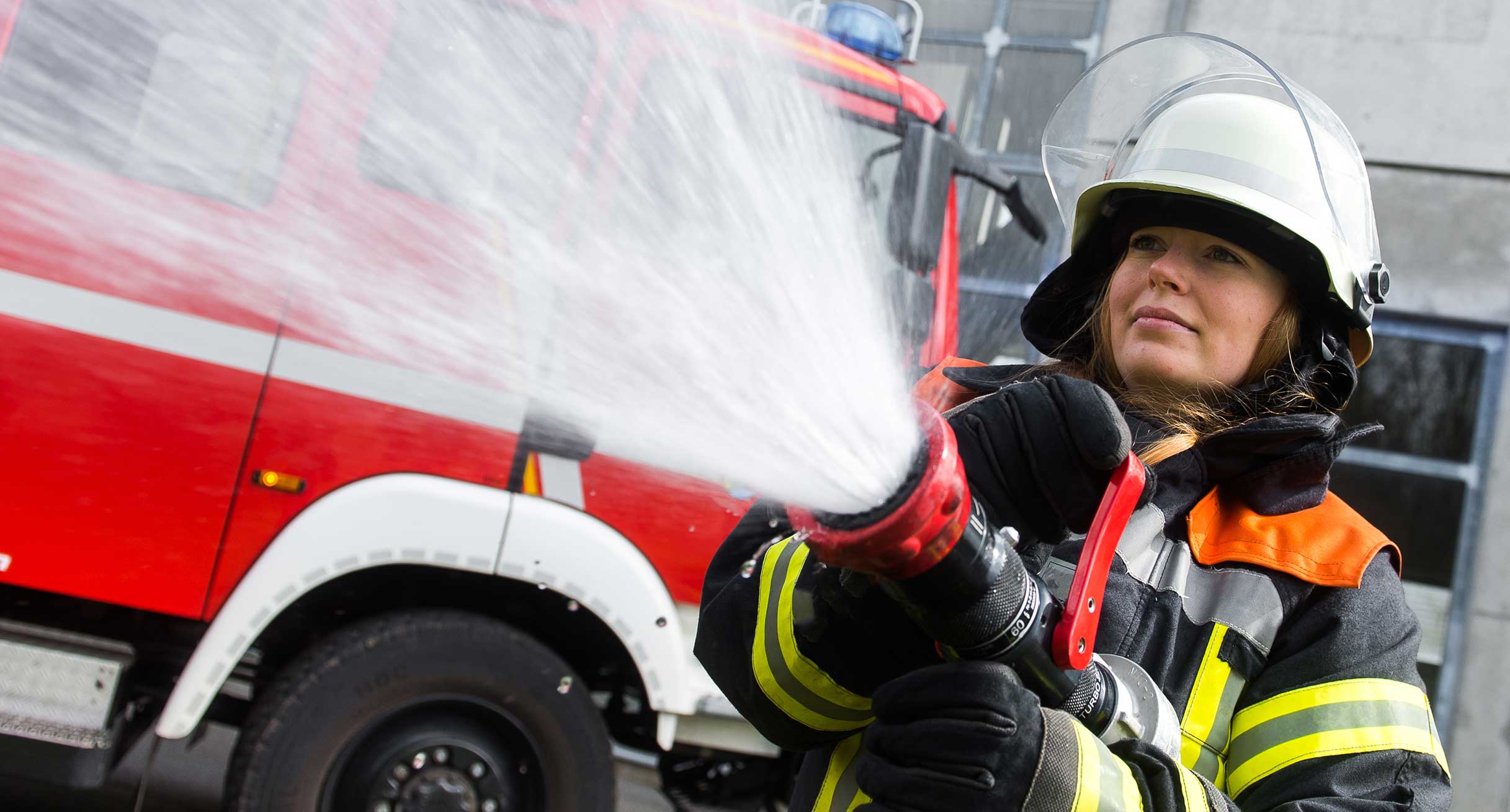 Eine junge Frau bei einer Übung der freiwilligen Feuerwehr.']
